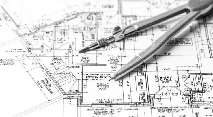 Plans d’architecte et compas sur une table de travail